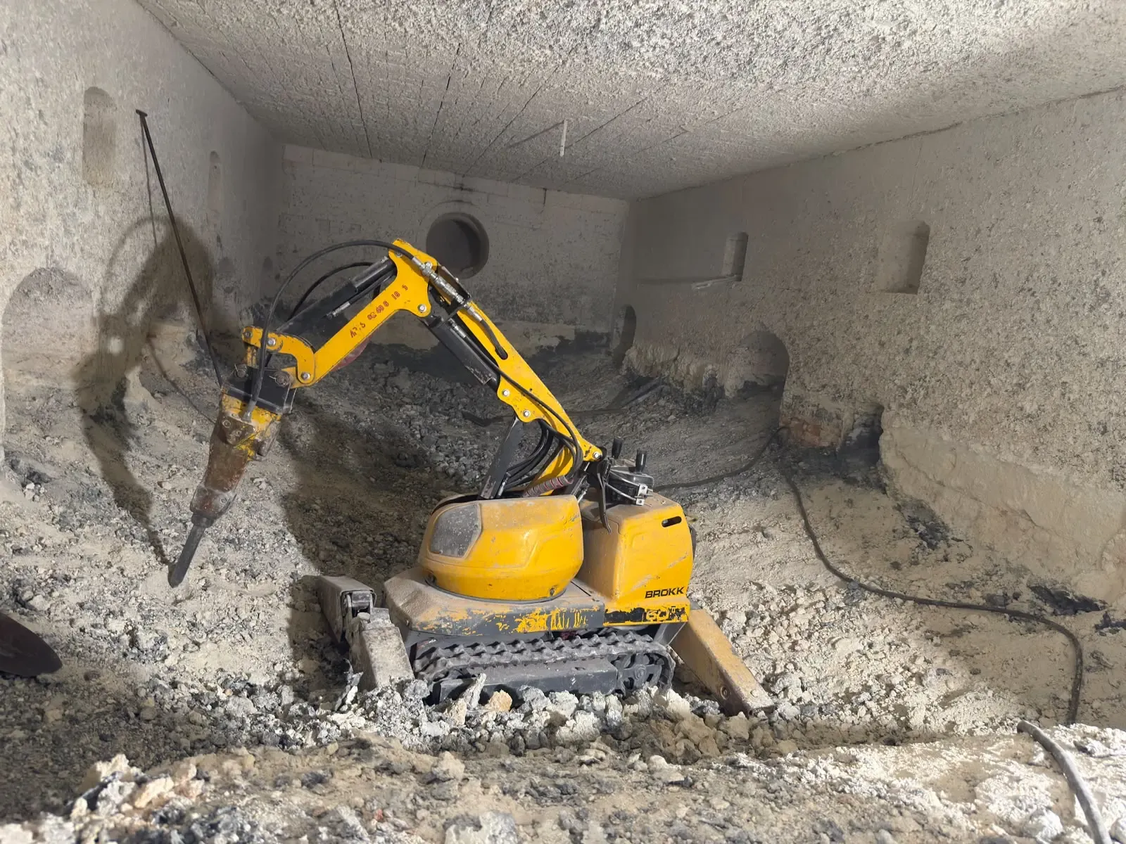 Robot BROKK au brise-roche en débriquetage à l'intérieur d'un four industriel
