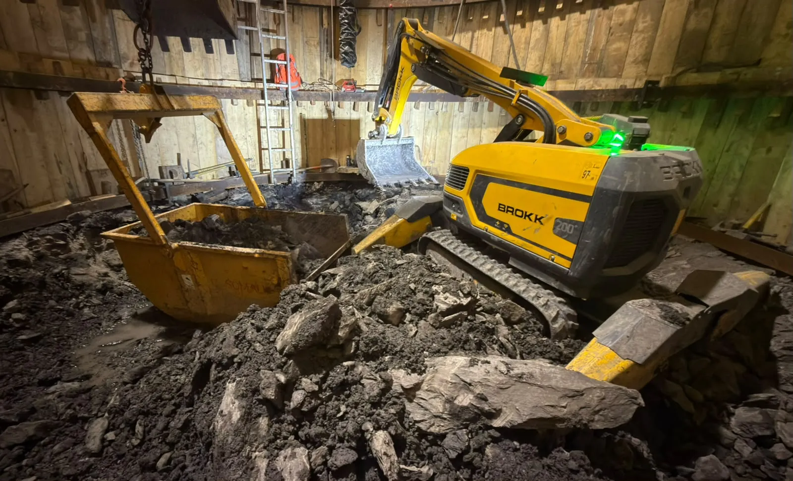 Robot BROKK 200 au godet en excavation dans un puits blindé souterrain